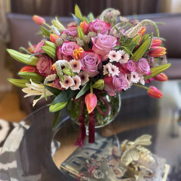 Pink rose and tulip bouquet in a glass vase