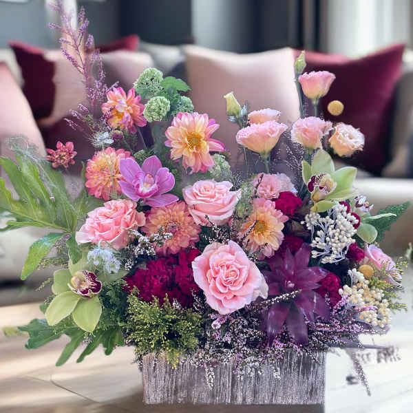 Pink and peach floral arrangement in a silver rectangular container