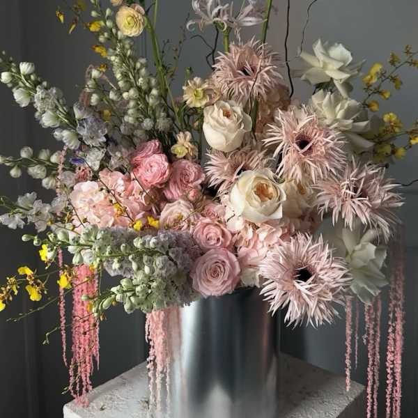 Tall pastel floral arrangement in a silver cylinder vase