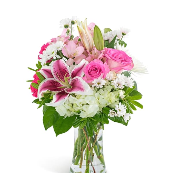 Pink lilies and roses in a clear glass vase