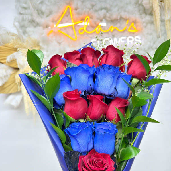 Bouquet of red and blue roses wrapped in blue paper with a ribbon
