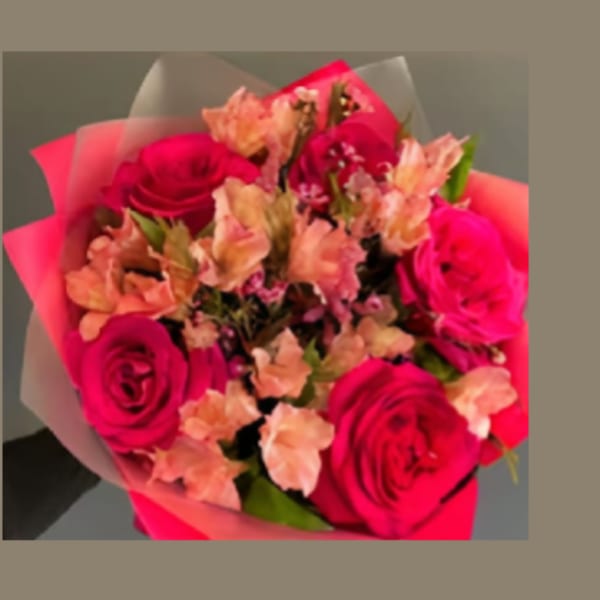 Bouquet of hot pink roses and peach flowers wrapped in pink paper