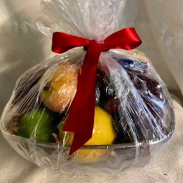 Cellophane-wrapped basket of assorted fruit tied with a red ribbon