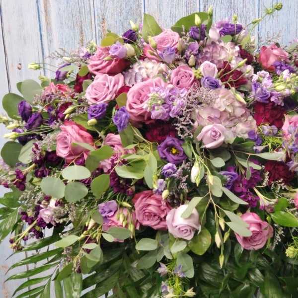 Large bouquet of pink and purple roses with mixed greenery