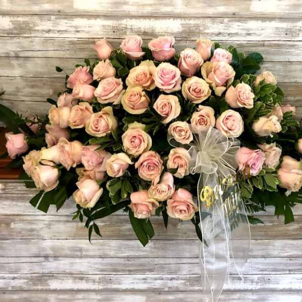 Large bouquet of pale pink roses with a white ribbon bow