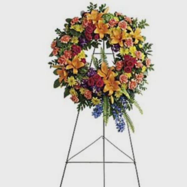Standing floral wreath on an easel with mixed bright flowers