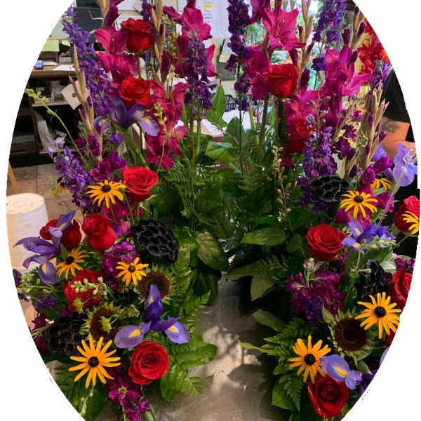 Tall mixed floral arrangement with red roses and purple blooms