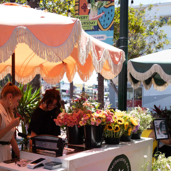 Outdoor flower market stall with buckets of colorful bouquets and potted blooms