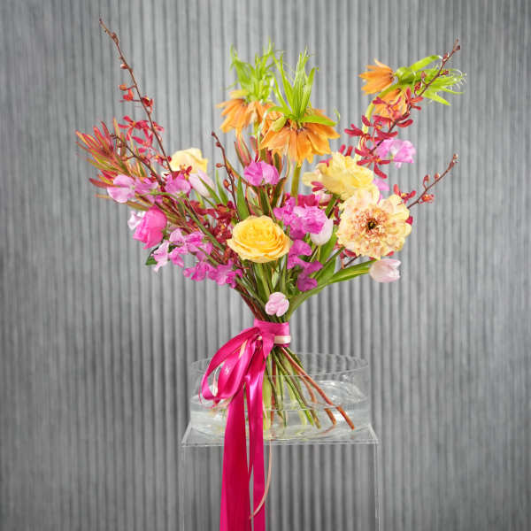 Colorful bouquet of pink, yellow, and orange flowers tied with a ribbon