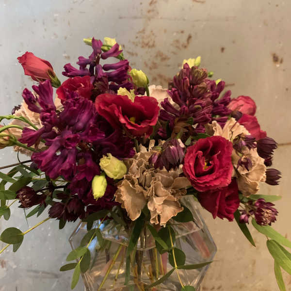 Bouquet of red and purple flowers in a clear glass vase