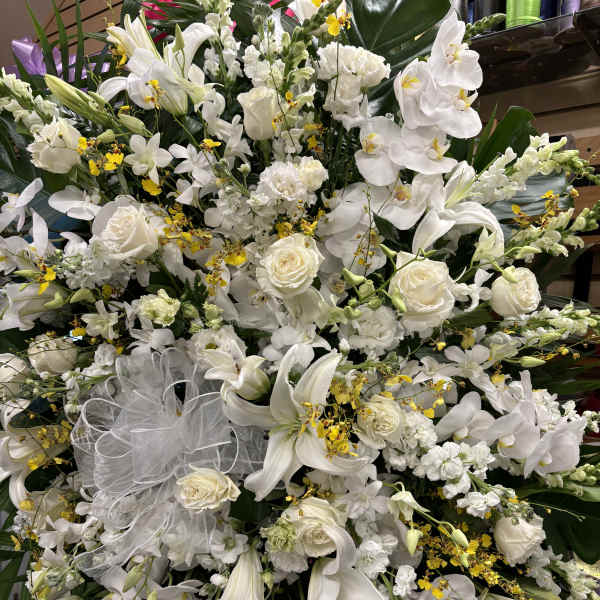 Large white floral spray with lilies, roses, and orchids