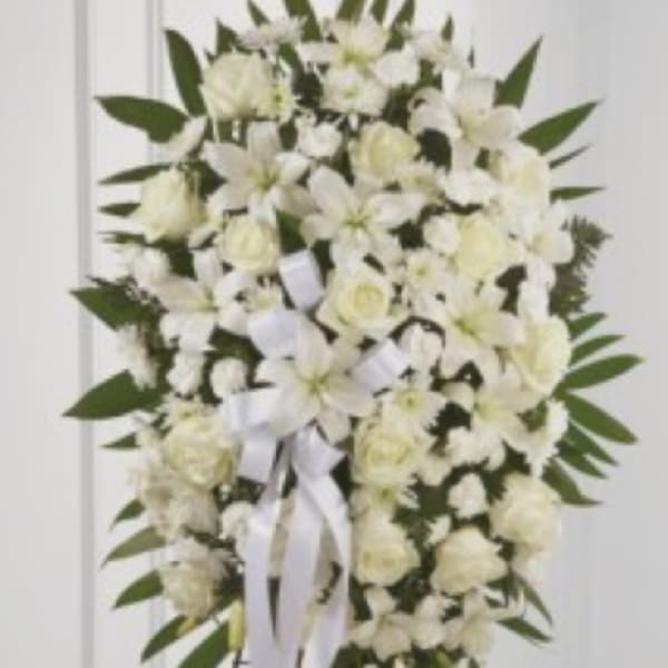 White floral standing spray with ribbon on an easel