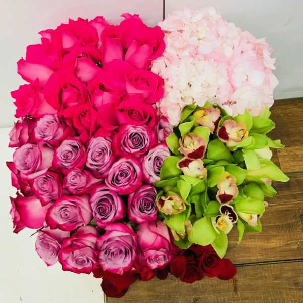 Heart-shaped bouquet of pink, white, green, and red flowers