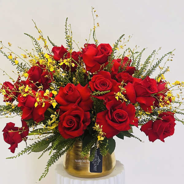 Red roses with yellow accents in a gold vase