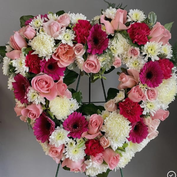 Heart-shaped floral wreath with pink roses, white mums, and magenta gerberas