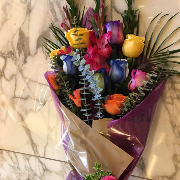 Bouquet of multicolored roses wrapped in purple and brown paper