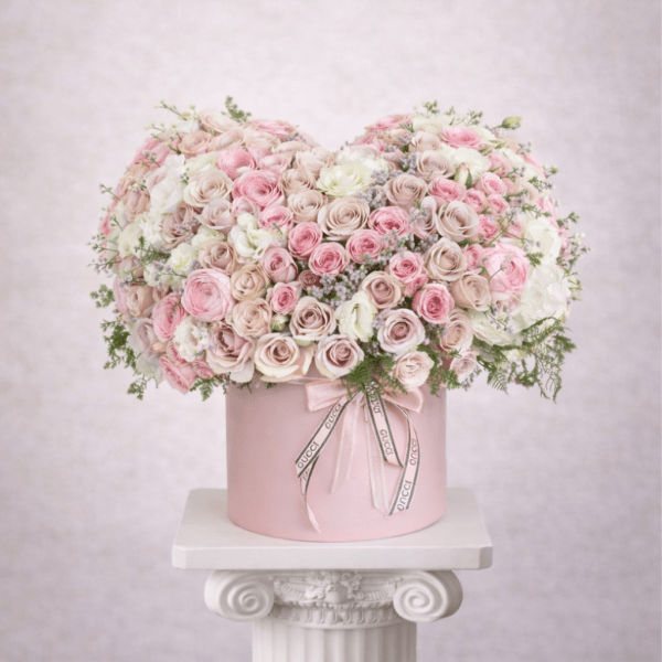 Pink and white rose arrangement in a round pink box