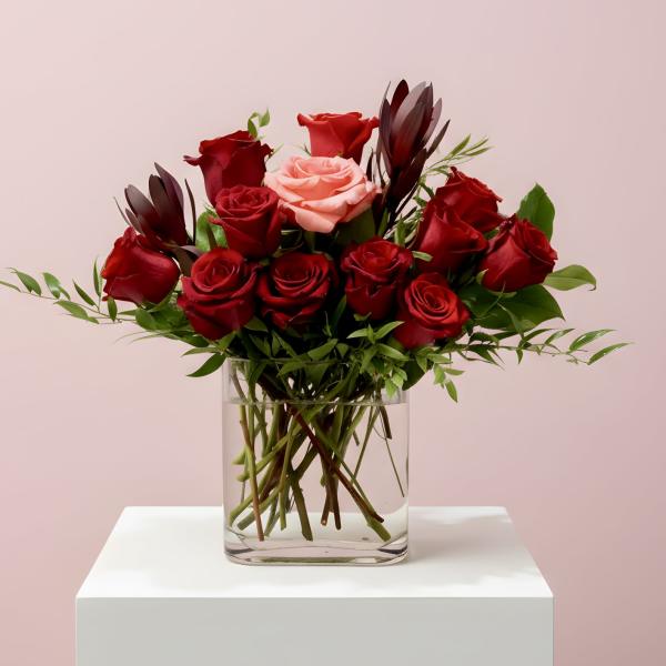 Bouquet of red and pink roses in a clear glass vase