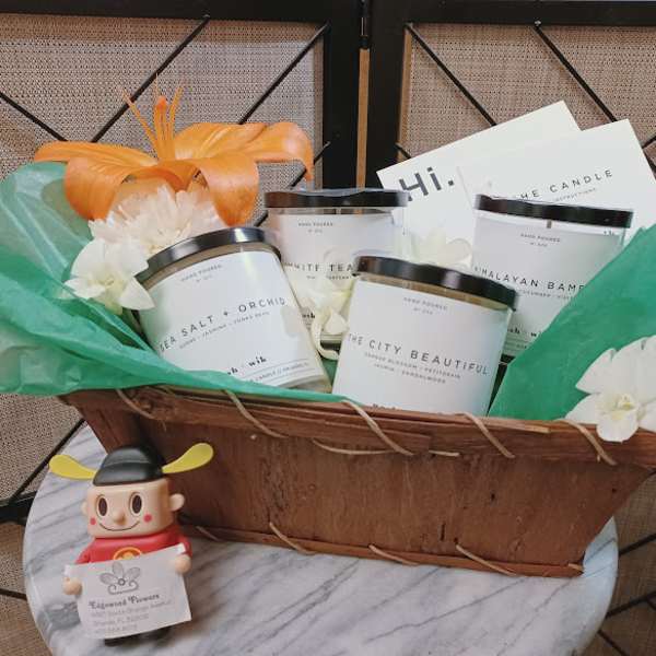Gift basket with candles, white flowers, and a small figurine
