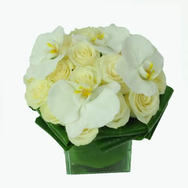White orchid and cream rose bouquet in a green vase