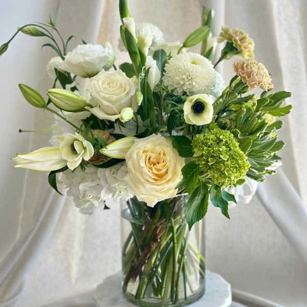 White and cream floral arrangement in a glass vase