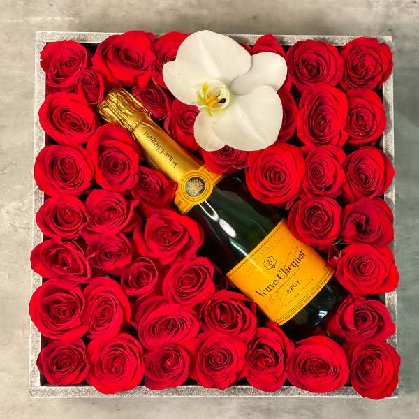 Box of red roses with a champagne bottle and white orchid