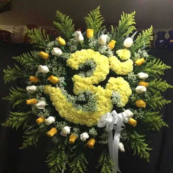 Large yellow and white floral standing wreath with ribbon