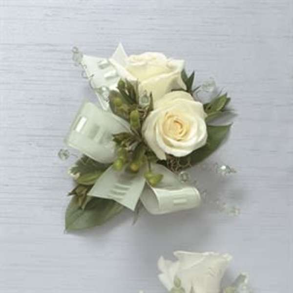 White rose boutonniere with ribbon and greenery