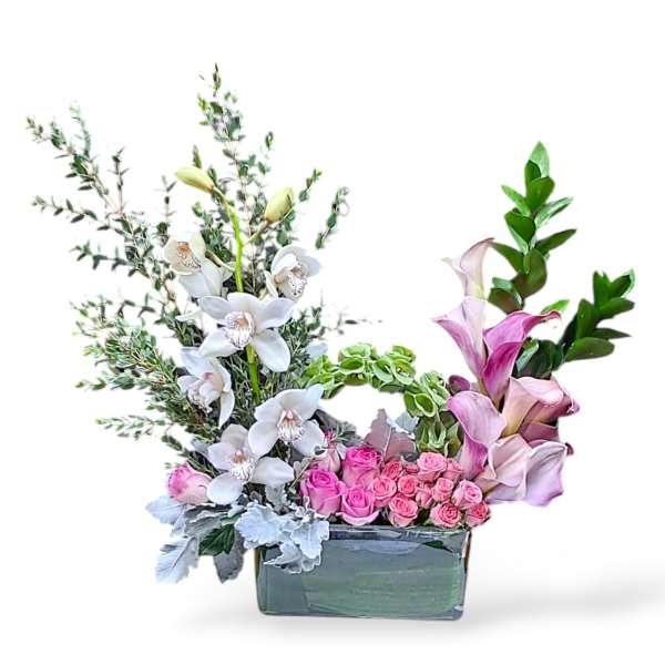 Pink roses and white orchids in a rectangular vase with greenery