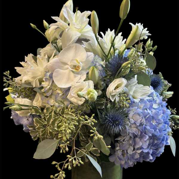 White and blue floral arrangement in a glass vase