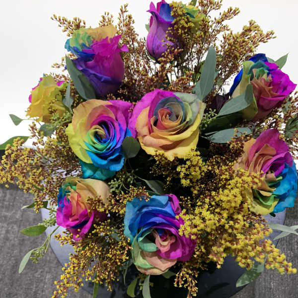 Bouquet of rainbow-colored roses with yellow filler flowers