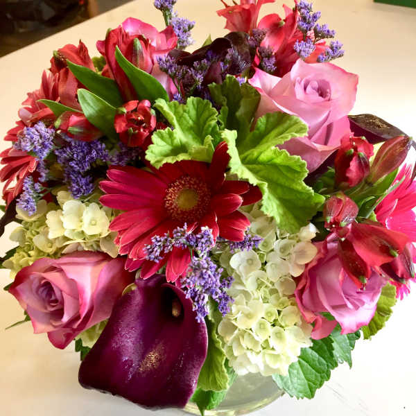 Mixed bouquet of pink roses, red gerberas, purple calla lilies, and hydrangeas