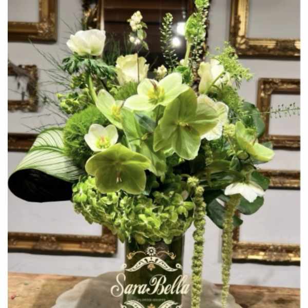 Green floral arrangement in a dark glass vase