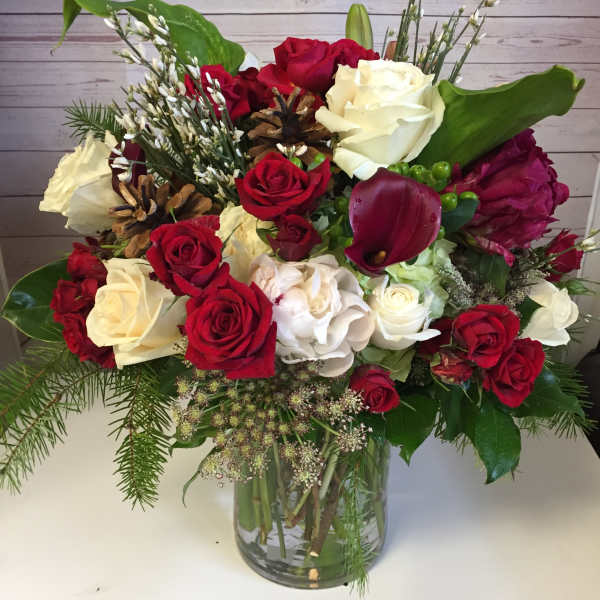 Bouquet of red and white roses with calla lilies in a glass vase
