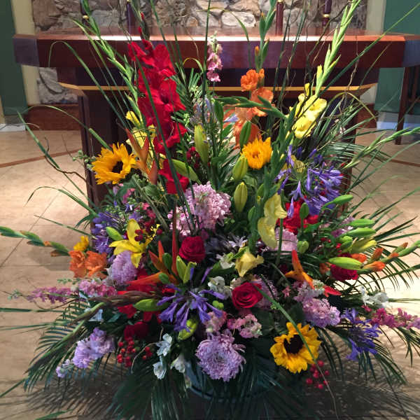 Large colorful floral arrangement with sunflowers, roses, and lilies