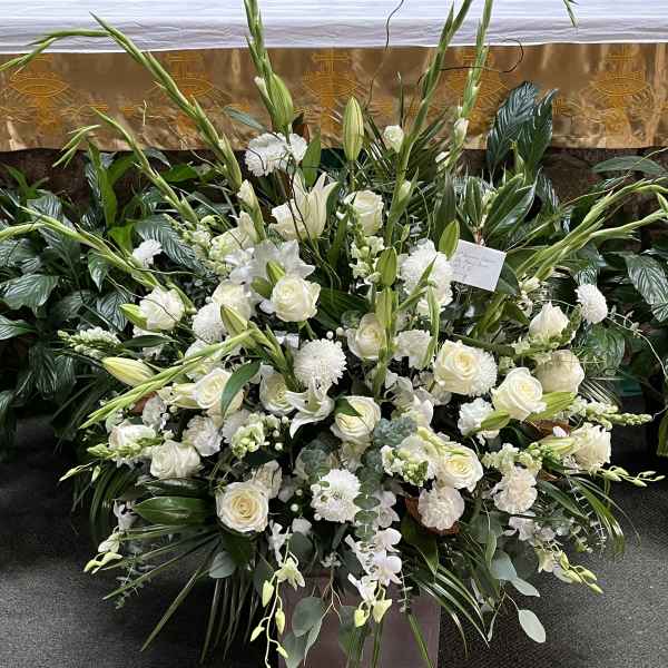 Large white floral funeral spray with roses and lilies