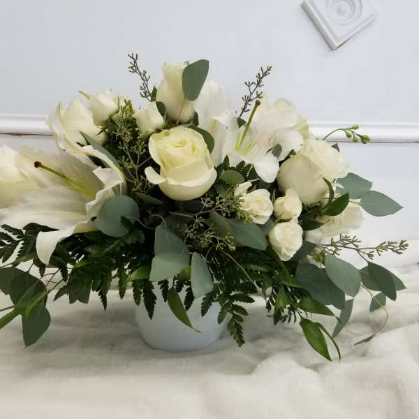 White roses and lilies arranged in a white vase