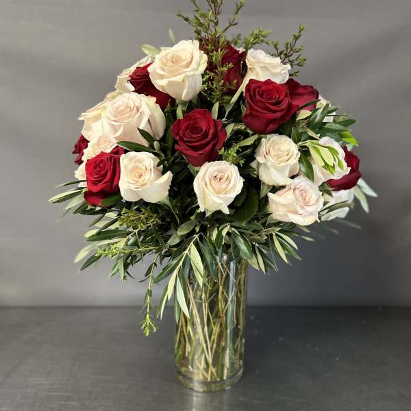 Red and white roses in a clear glass vase