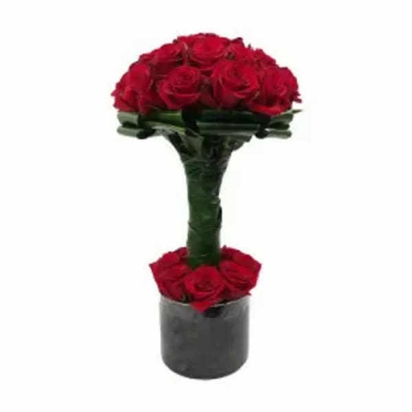 Red rose arrangement in a black cylindrical vase