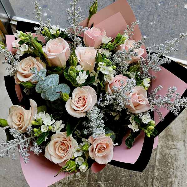 Bouquet of pale pink roses with white filler flowers and silver foliage