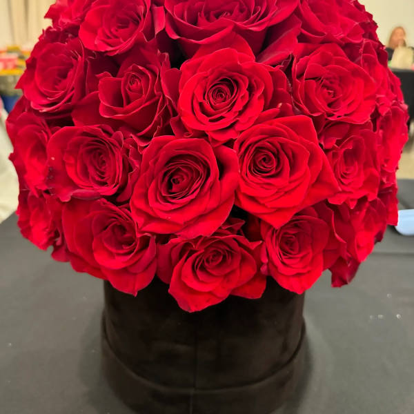 Round bouquet of red roses in a black box