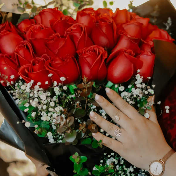 Bouquet of red roses with baby's breath in black wrap