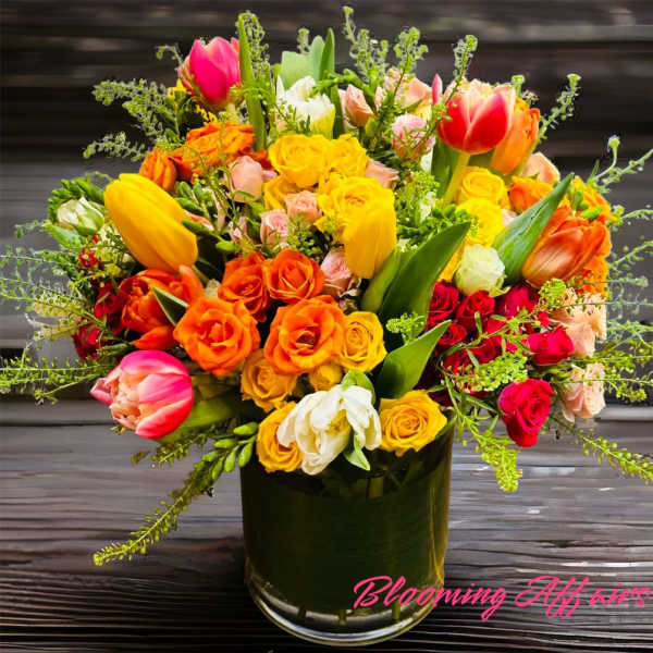 Colorful bouquet of tulips and roses in a glass vase