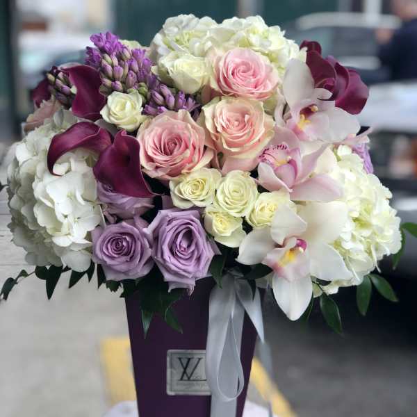 Bouquet of pink, white, and purple flowers in a tall purple vase