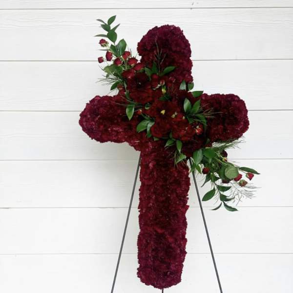Red floral cross on a stand with green accents