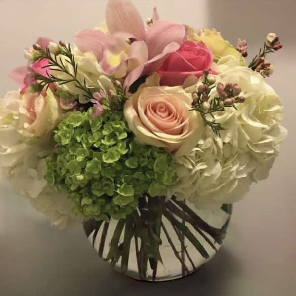 Bouquet of pink and cream roses with hydrangeas in a glass vase
