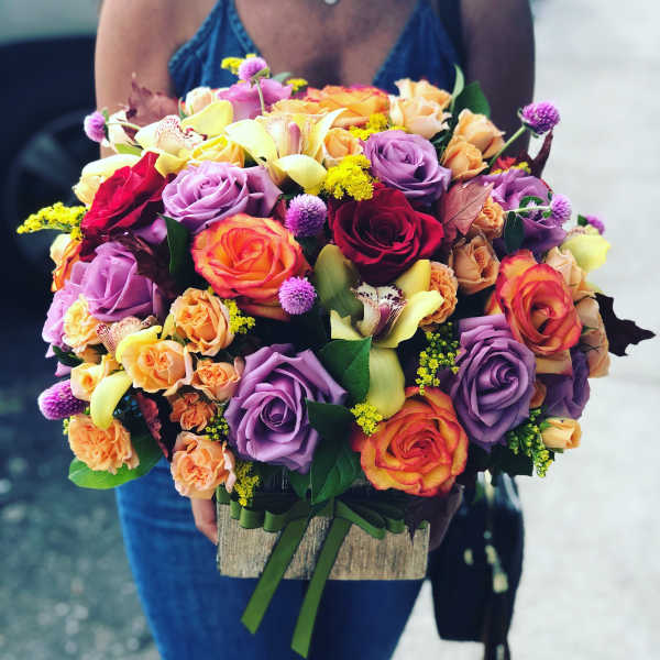 Mixed bouquet of roses, orchids, and calla lilies in a wooden box