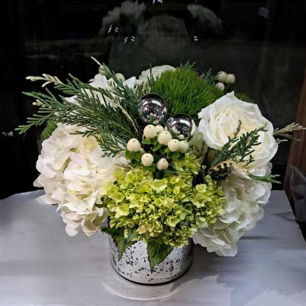 White floral arrangement with green hydrangeas in a speckled metal container