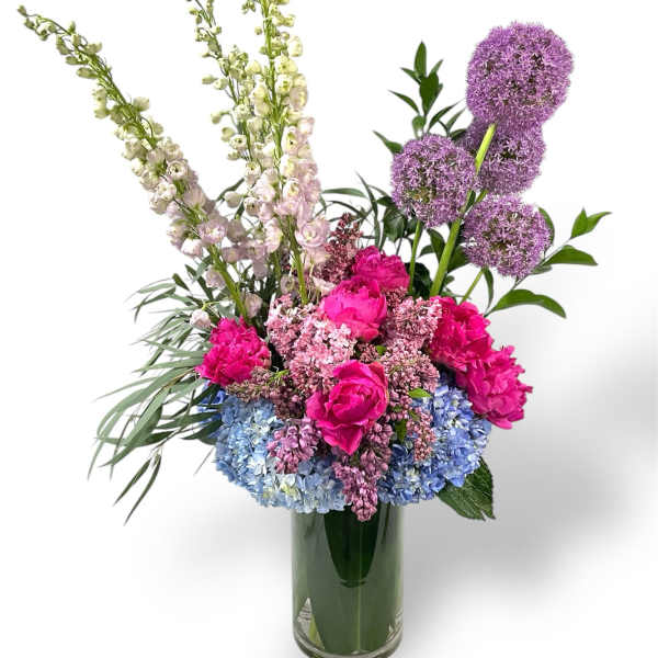 Colorful bouquet of pink, blue, and purple flowers in a glass vase