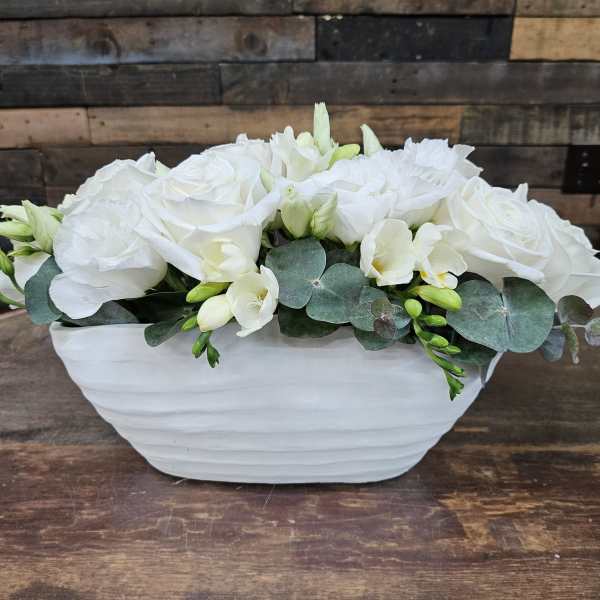 White roses and pale flowers in a white ceramic bowl